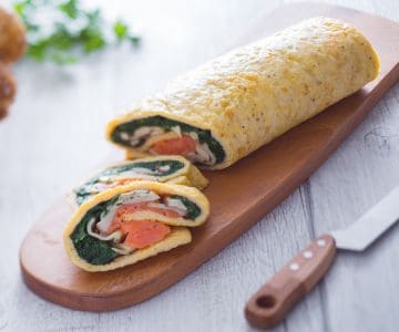 Rollo de salmón setas y espinacas salteadas
