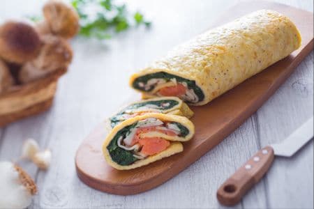 Rollo de salmón setas y espinacas salteadas
