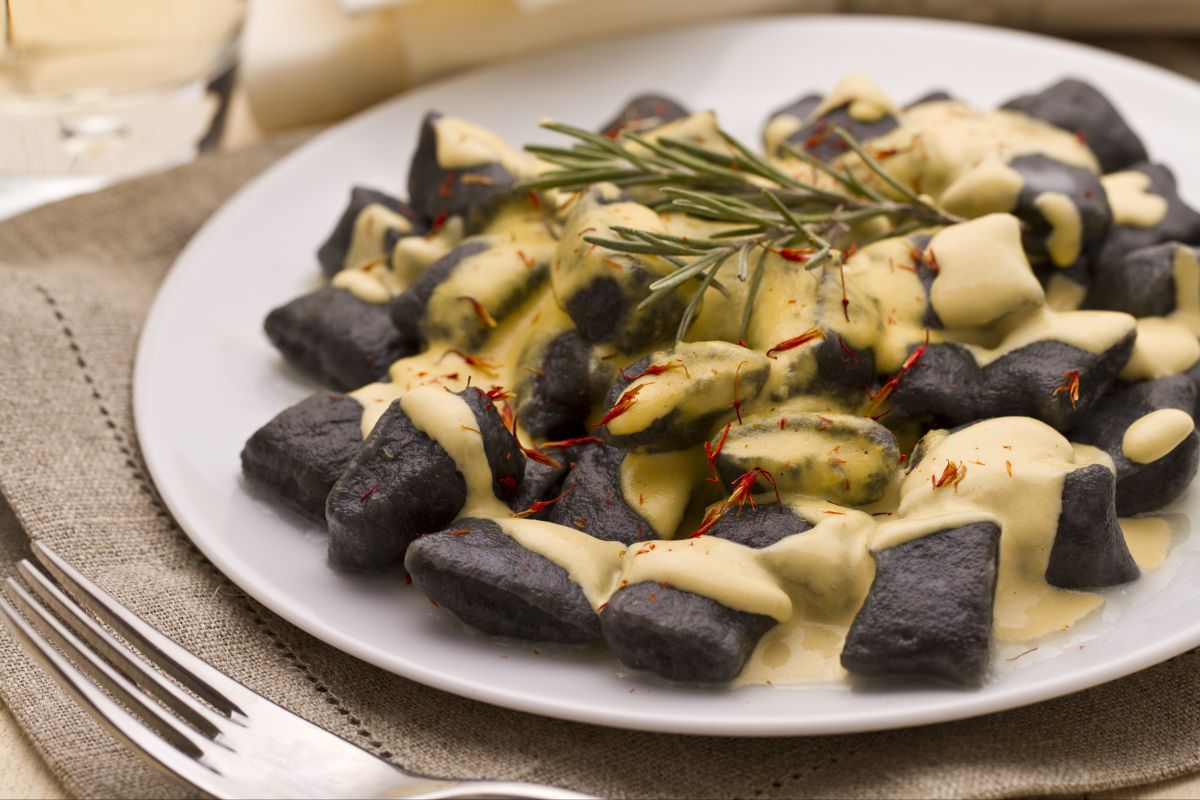 Ñoquis al nero di seppia con salsa de lubina y azafrán