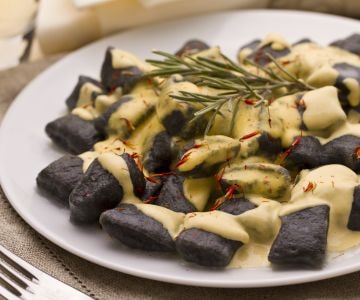 Ñoquis al nero di seppia con salsa de lubina y azafrán