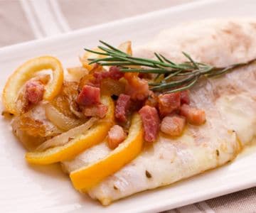 Lubina (róbalo) con panceta con cebollas y naranjas agridulces