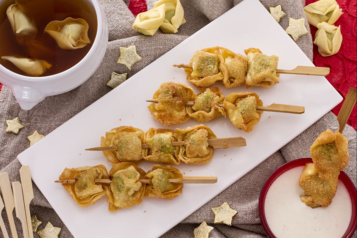 Brochetas de tortellini fritos con salsa de nata y parmesano