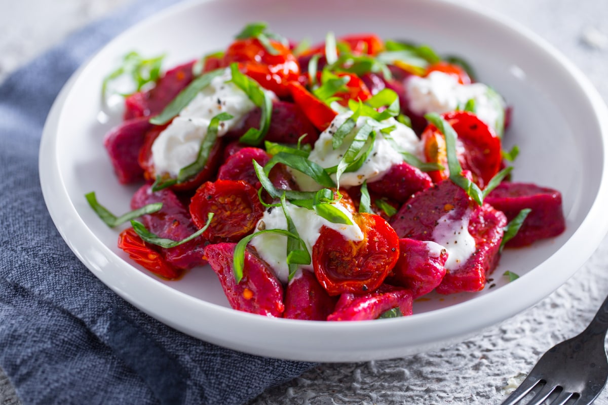 Ñoquis de remolacha con tomatitos y stracciatella