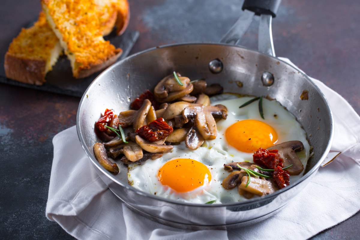 Huevos al plato con setas y tomates secos