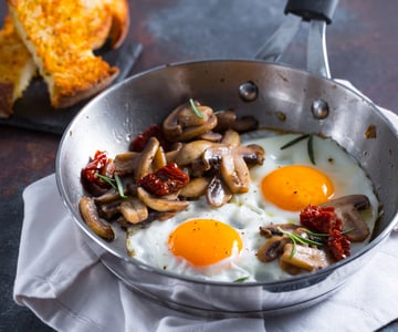 Huevos al plato con setas y tomates secos