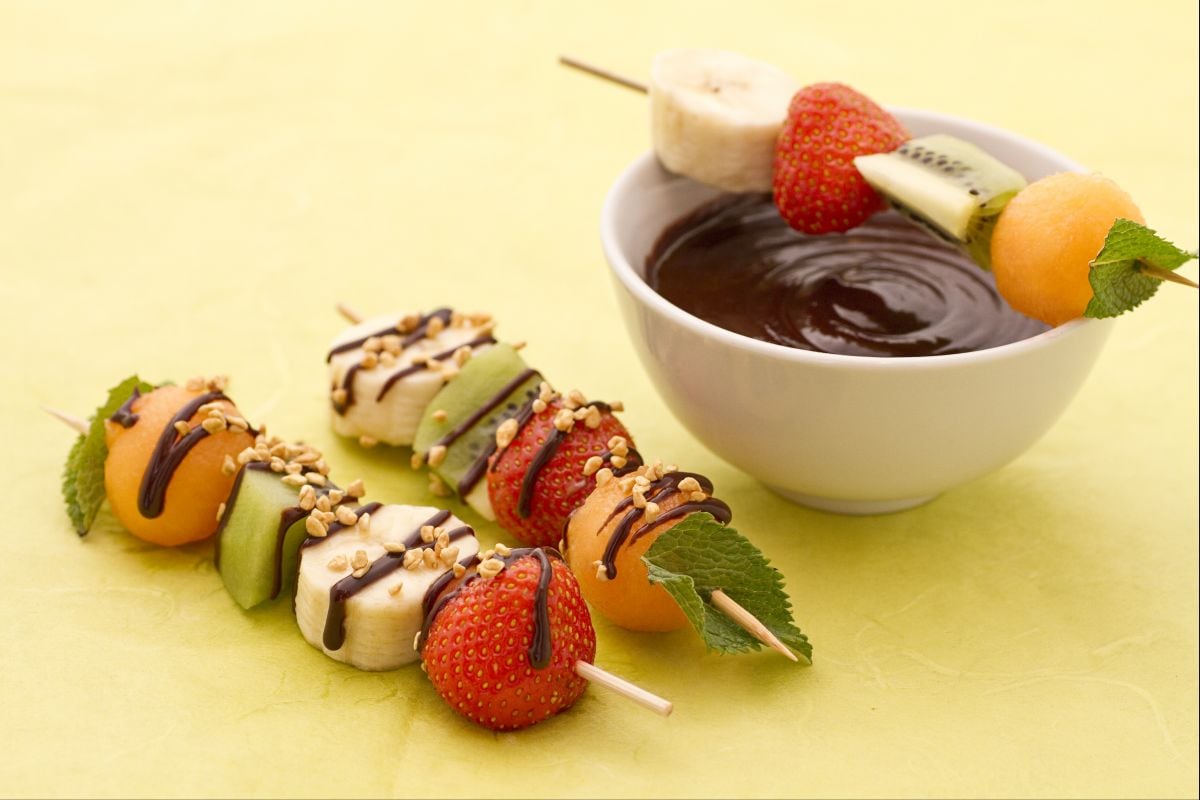 Brochetas de fruta con salsa de chocolate y granillo de avellanas