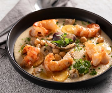 Crema de garbanzos con gambas, almejas y chirivía