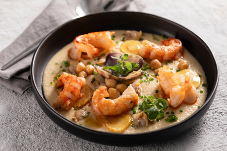 Crema de garbanzos con gambas, almejas y chirivía