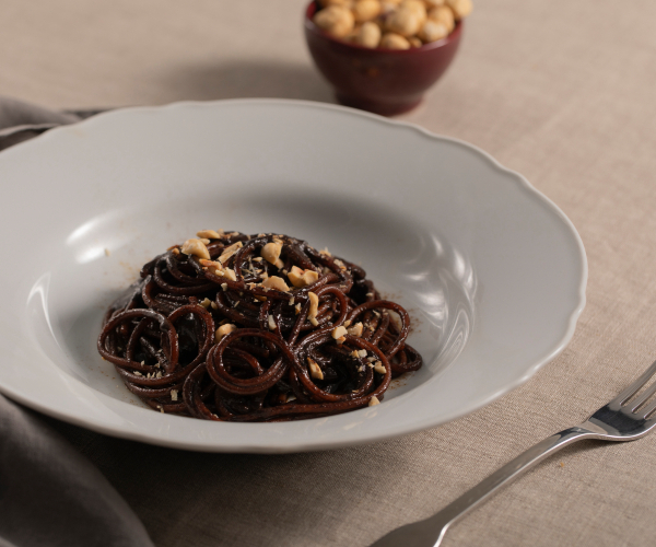 Espaguetis con crema de ajo negro, regaliz y avellanas