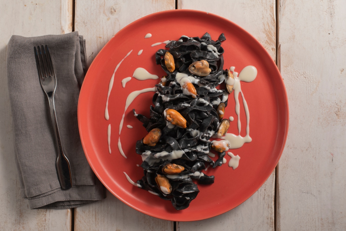 Tagliatelle al nero di sepia con pecorino, mejillones y lardo