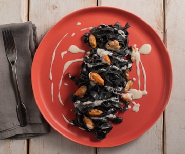 Tagliatelle al nero di sepia con pecorino, mejillones y lardo