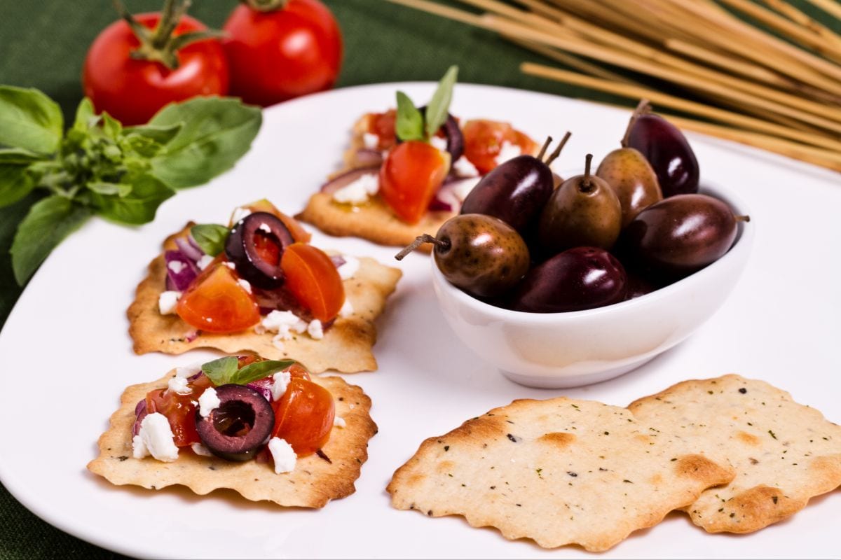 Hojaldres con aceitunas, tomate y migas de feta