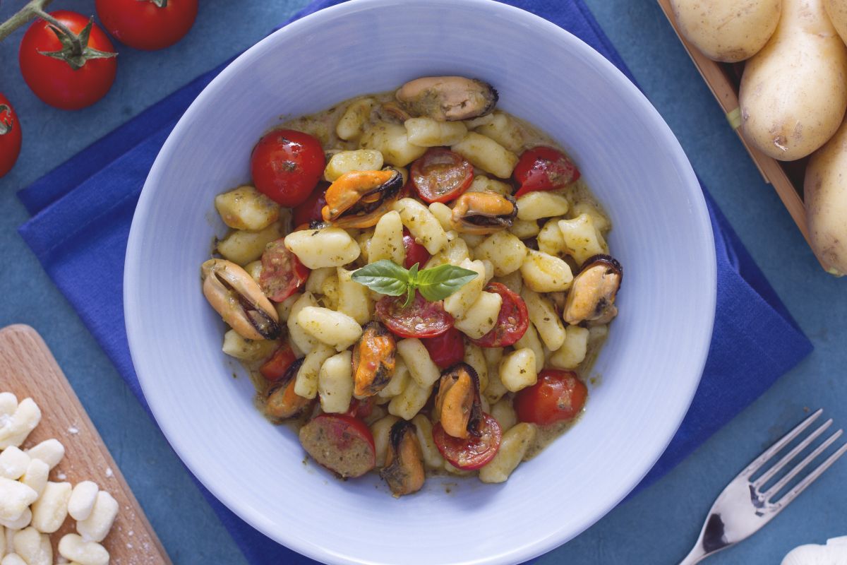 Chicche con tomatitos, pesto y mejillones