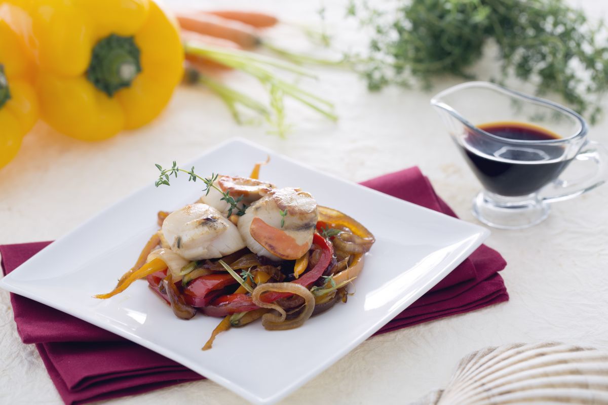 Vieiras sobre cama de cebollas caramelizadas con zanahorias y pimientos a la soja