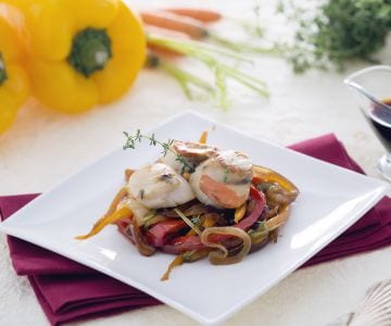 Vieiras sobre cama de cebollas caramelizadas con zanahorias y pimientos a la soja