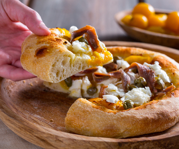 Pizza con tomatitos amarillos, anchoas y alcaparras