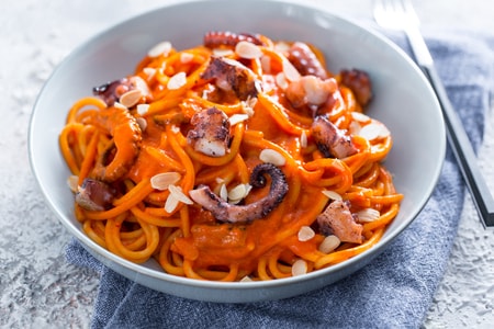 Espaguetis con crema de pimientos y pulpo