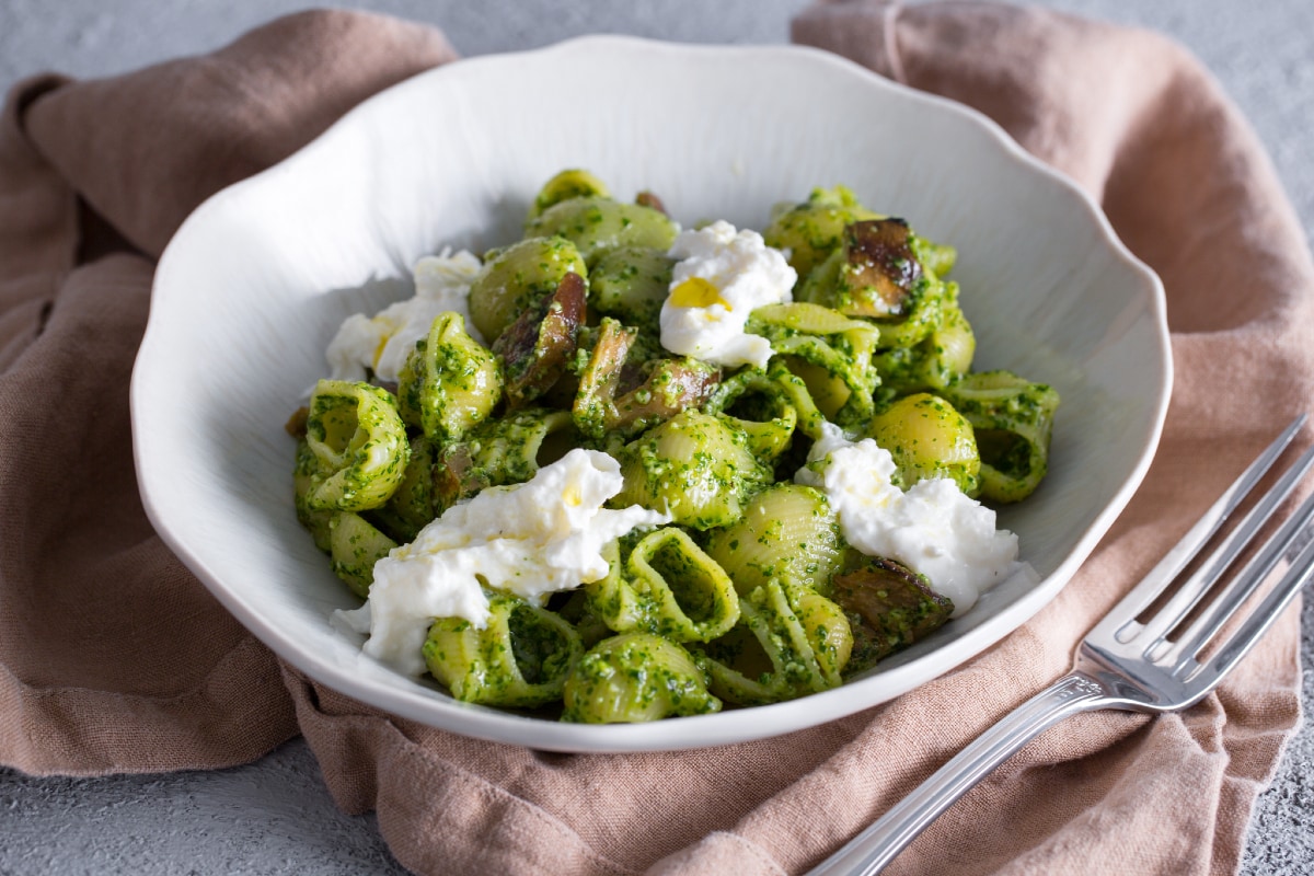 Pasta con pesto de rúcula, berenjenas en aceite y stracciatella