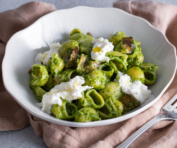 Pasta con pesto de rúcula, berenjenas en aceite y stracciatella