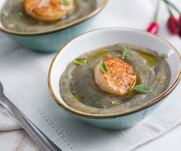 Vieiras sobre crema de alcachofas y hierbas aromáticas