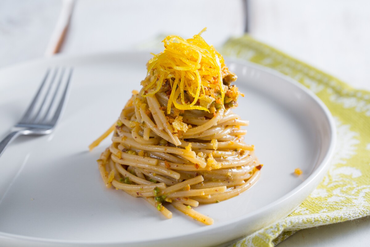 Spaghettoni con colatura de anchoas, pistachos y limón confitado