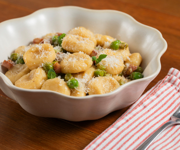 Ñoquis de ricotta con guisantes, pecorino y papada
