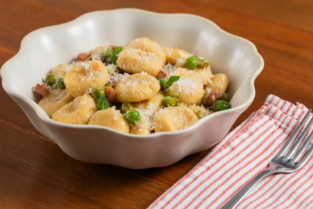 Ñoquis de ricotta con guisantes, pecorino y papada