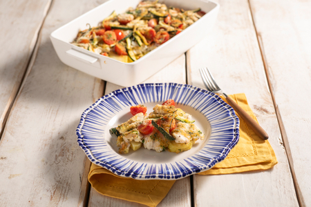 Lubina gratinada con tomates, patatas y calabacines