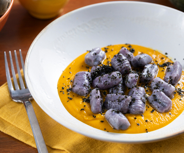 Ñoquis de patatas violetas con crema de calabaza y col rizada