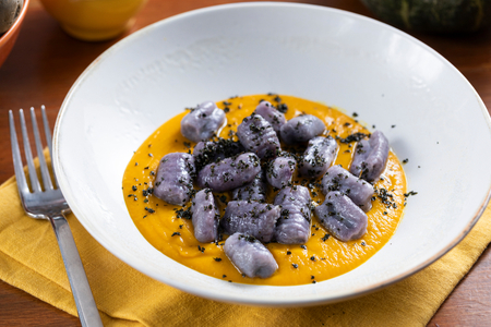 Ñoquis de patatas violetas con crema de calabaza y col rizada