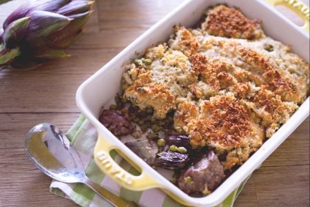 Cordero gratinado con alcachofas y guisantes