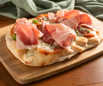 Pinsa con tomates asados, burrata y jamón cocido
