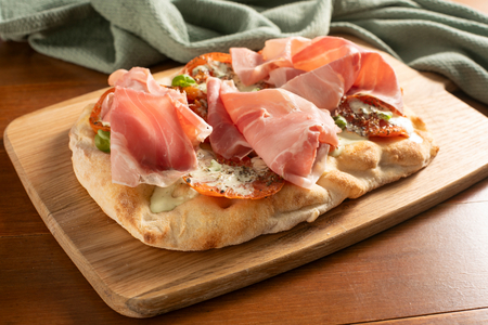 Pinsa con tomates asados, burrata y jamón cocido