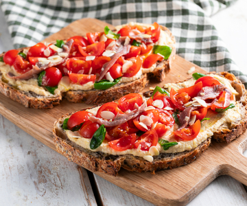 Bruschetta con tomates cherry, hummus y anchoas