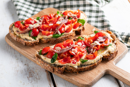 Bruschetta con tomates cherry, hummus y anchoas