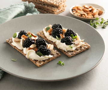 Tostas crujientes con crema de queso, miel, moras y almendras tostadas