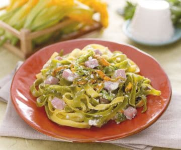 Paja y heno con crema de ricotta, flores de calabacín y trocitos de jamón cocido