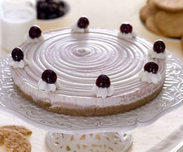 Tarta de queso bicolor con nata y guindas