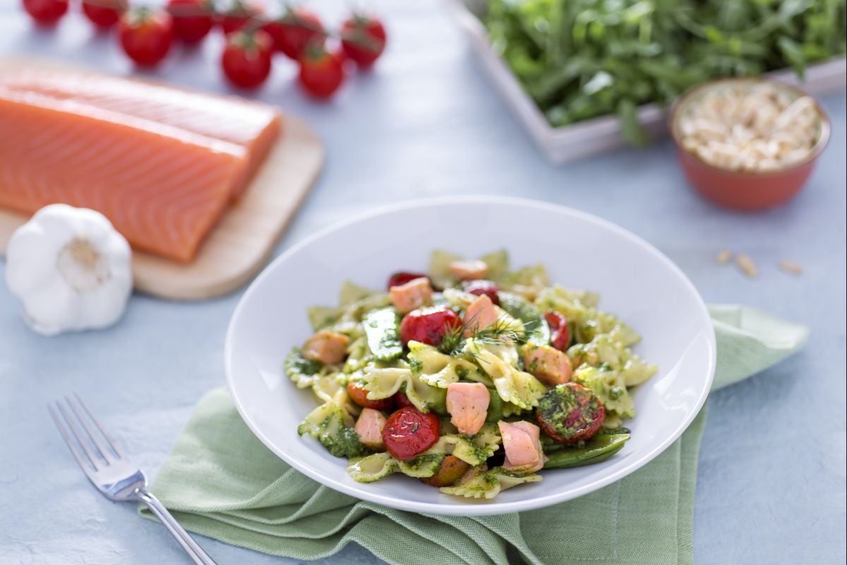 Farfalle con salmón, tirabeques y tomatitos confitados con pesto de rúcula
