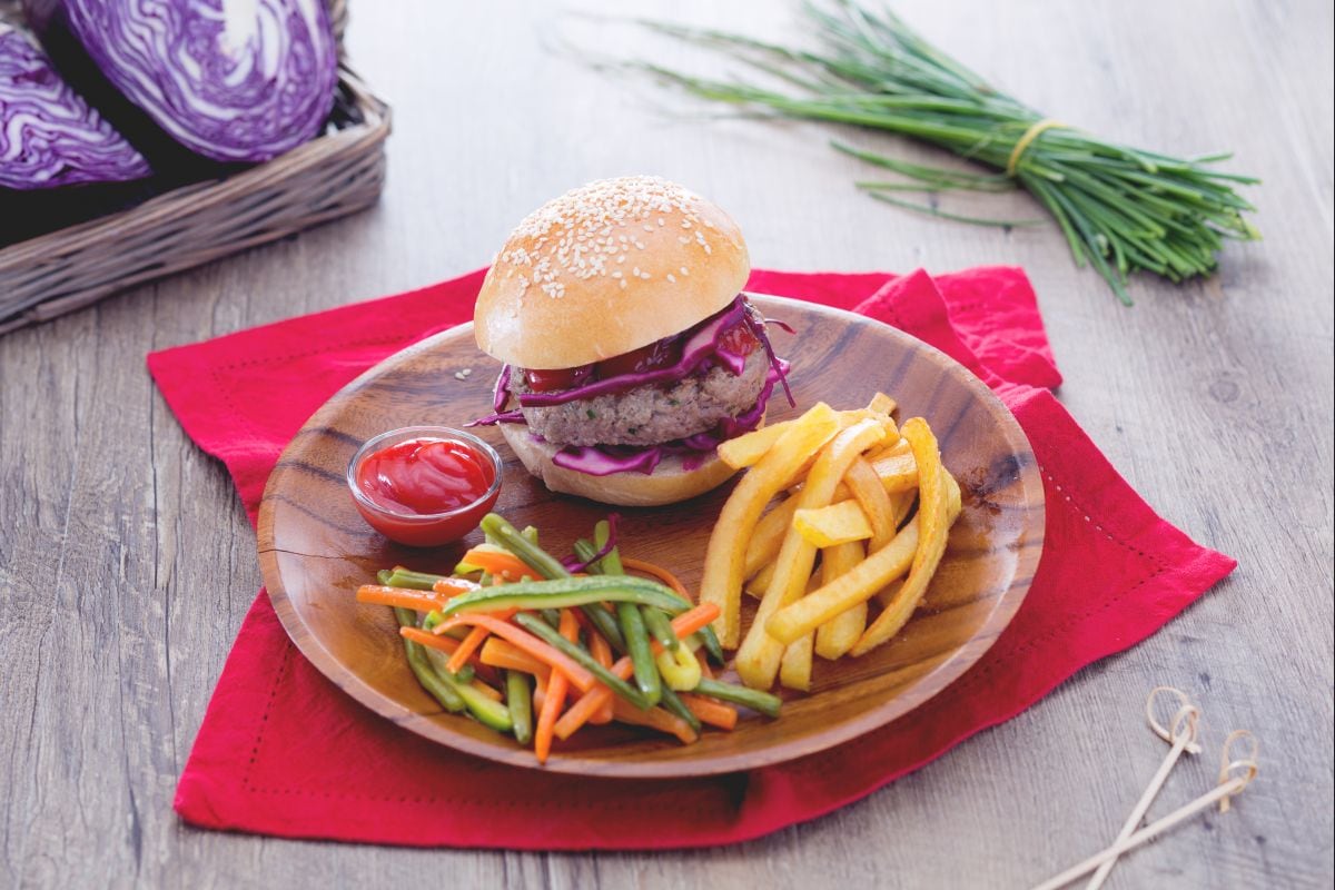 Hamburguesa con hierbas aromáticas con verduras mixtas y patatas fritas