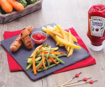 Salchichas a la parrilla con patatas fritas y verduras salteadas