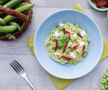 Spaghetti integrales con pesto de guisantes, tomates secos y stracciatella