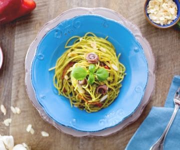 Espaguetis al pesto con anchoas y pimientos