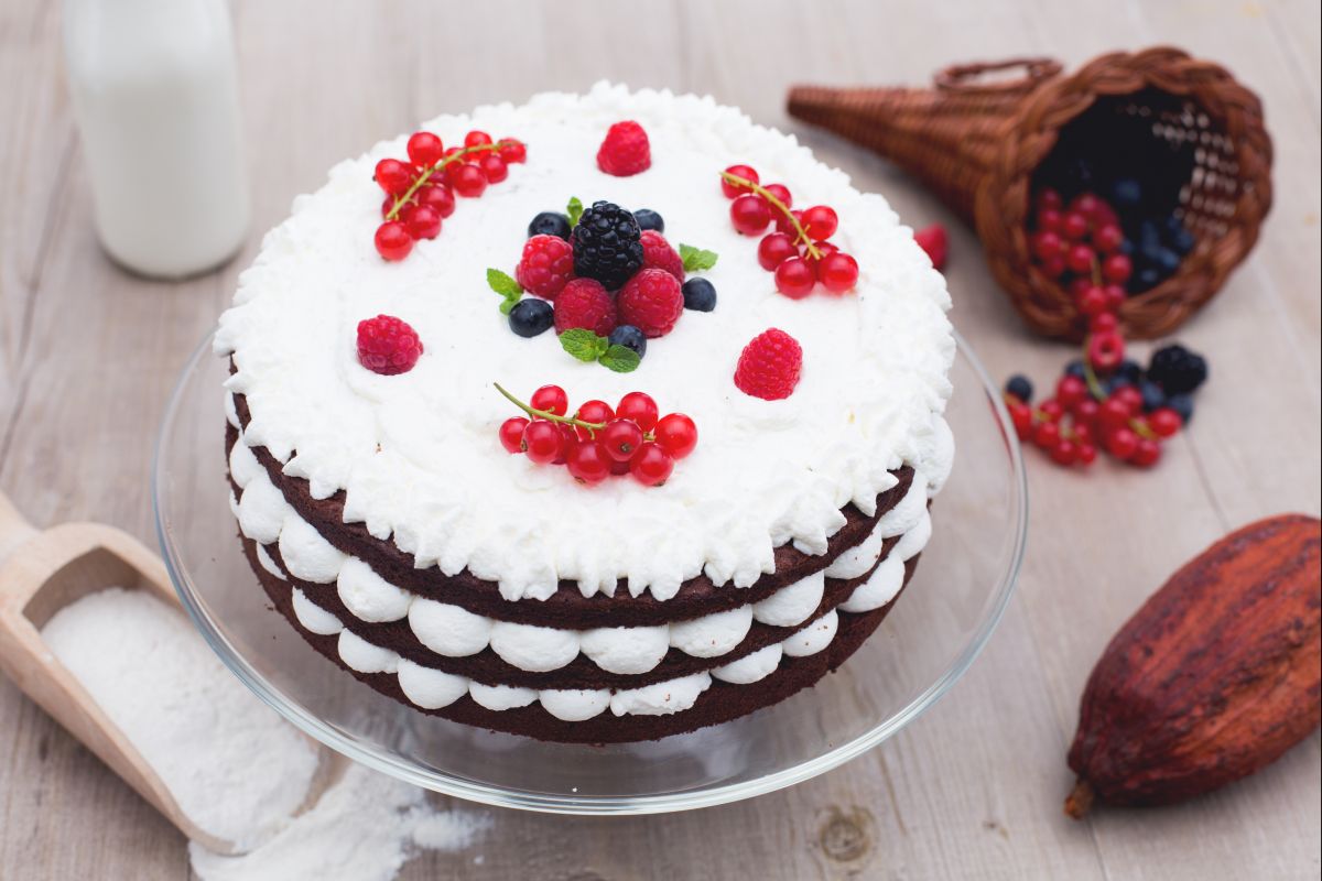 Tarta de pisos de chocolate con nata y frutos del bosque