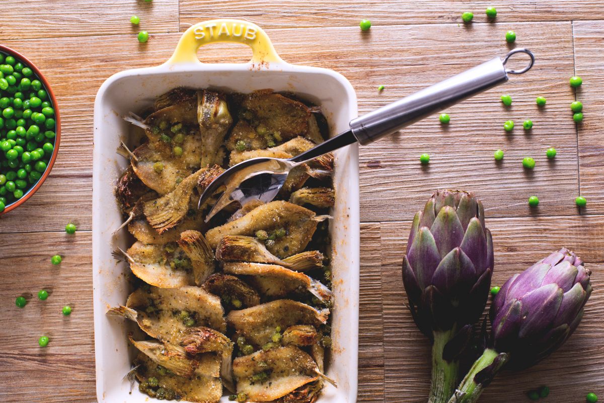 Alaccia al horno con alcachofas y guisantes
