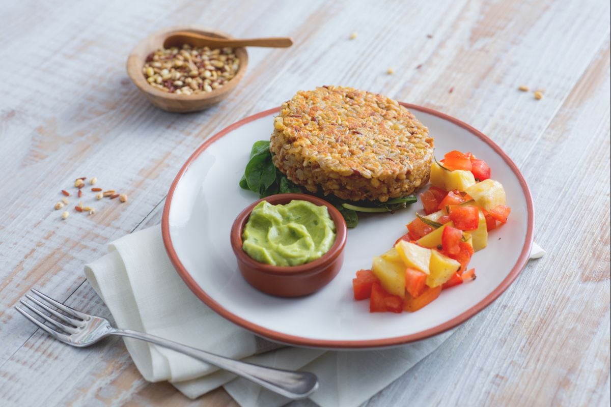 Hamburguesa de cereales y arroz rojo con hummus de aguacate