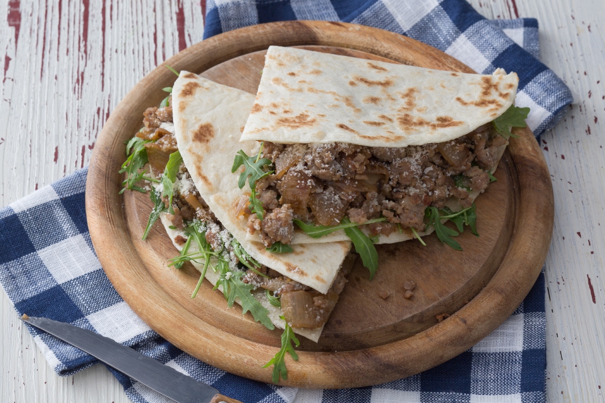 Piadina con salchicha y cebollas guisadas