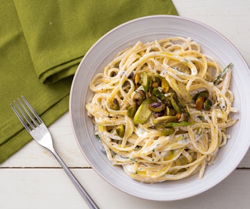 Pasta con crema de ricotta, espárragos y pistachos